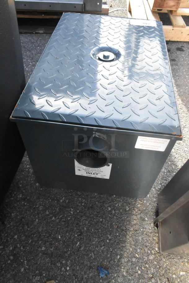 BRAND NEW SCRATCH AND DENT Watts WD-20 Grease Interceptor, 40 lb. capacity, gray metal box, labeled inlet and flow.