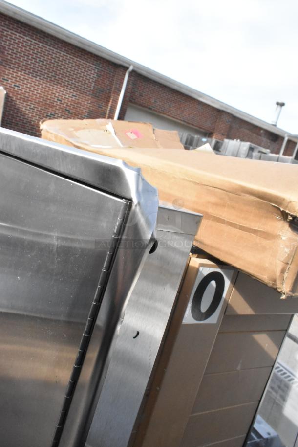Stainless steel wall mount trash and towel dispenser, new with visible dents on corners, packaging slightly damaged.