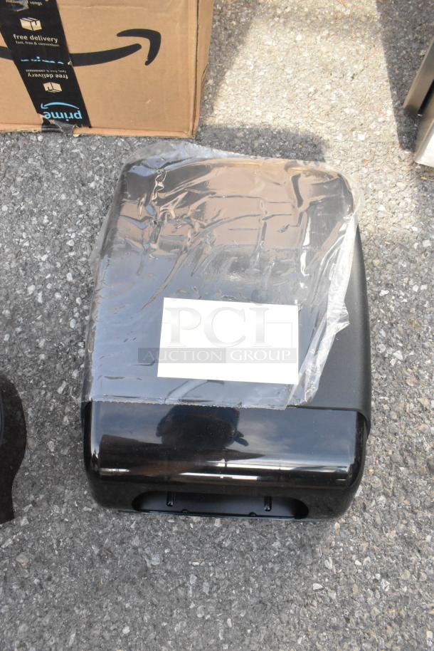 Lot of 2 brand new black poly wall mount dispensers, minor scratches and dents, in packaging.