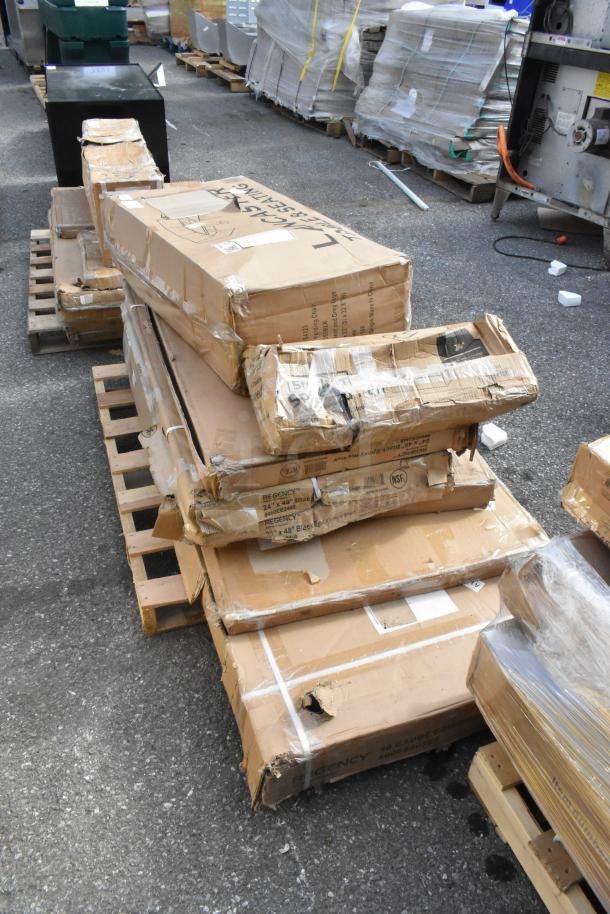 Boxes of 8 new scratch and dent items, including folding table and equipment stand, on pallets. Boxes show visible wear.