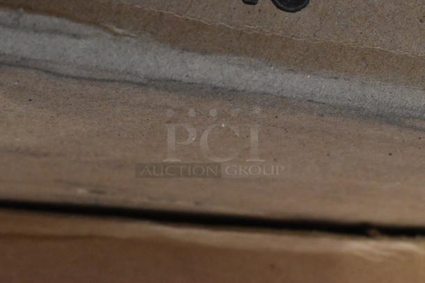 Cardboard packaging showing visible wear; contains new scratch and dent items including a folding table and equipment stand.