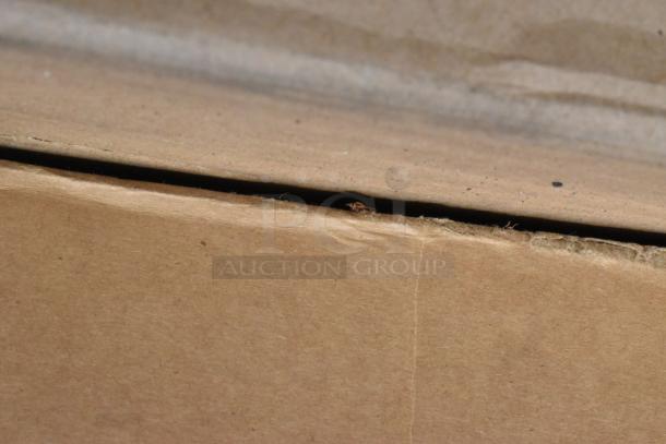 Cardboard box showing slight edge wear, part of an auction lot with 8 scratch and dent items including a folding table and equipment stand.