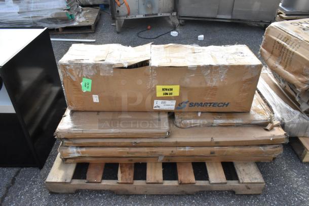 Cardboard boxes labeled "Spartech" with visible damage, containing new scratch and dent items, placed on a wooden pallet.