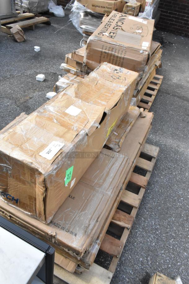 Stack of unopened boxes on wooden pallets, labeled "Lancaster Table & Seating" and "Made in China," showing signs of wear.