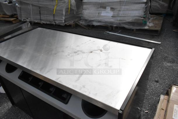 Brand new 168OCS490TRSF All State Manufacturing 49"x23.25"x34" stainless steel coffee stand, includes condiment tray and trash receptacles, slight scratches visible.