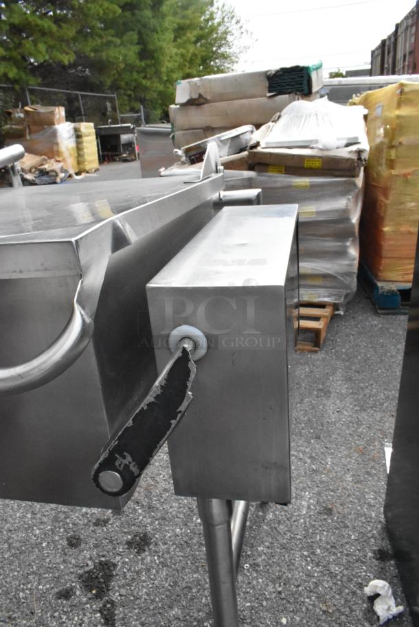 Stainless steel commercial braising pan with floor stand, featuring manual tilt handle and sturdy construction; used condition.