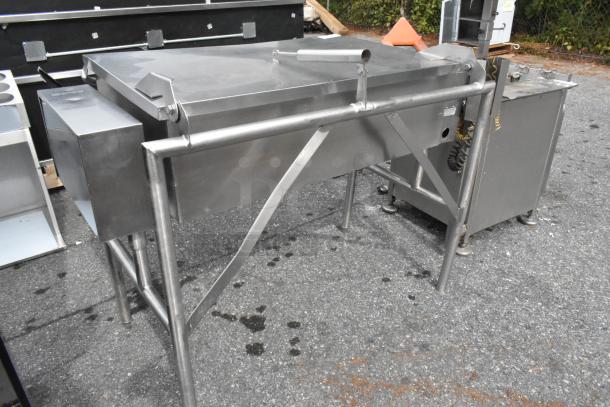 Stainless steel commercial braising pan, floor style, sturdy metal construction, appears in good condition.