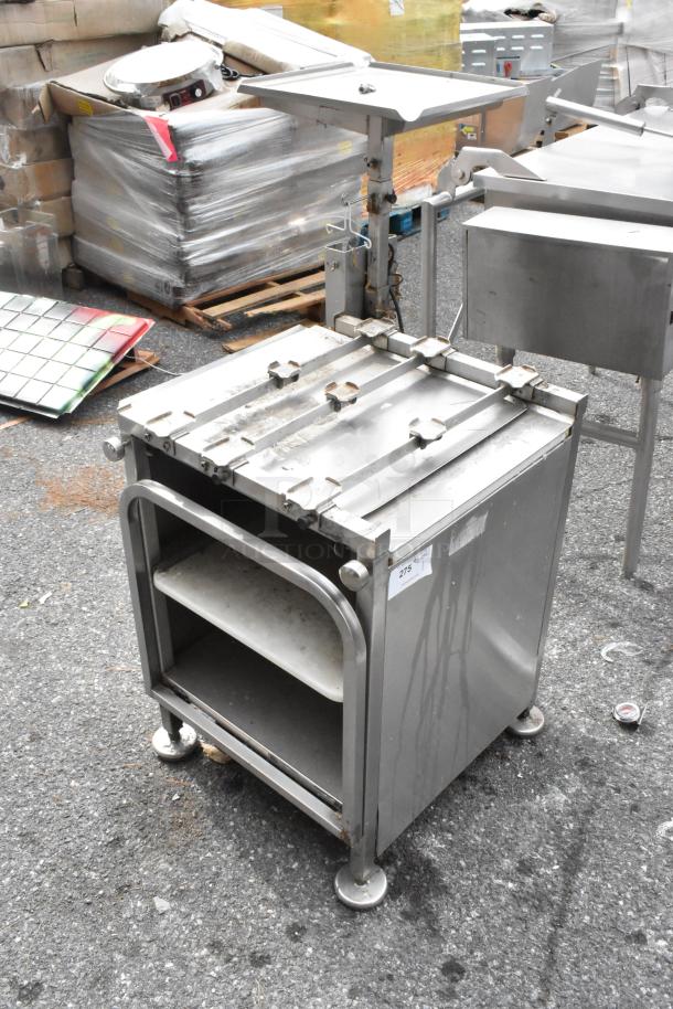 M&E Metal Equipment Stand with shelves, stainless steel, industrial-grade, visible surface wear, tag labeled "275" attached.