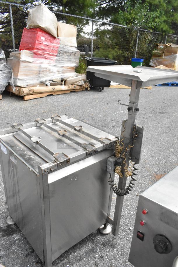 Metal equipment stand by M&E. Features sturdy construction with adjustable height. Shows moderate wear. Ideal for industrial use.