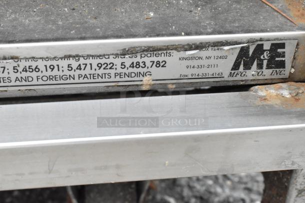 M&E Metal Equipment Stand, sturdy construction with visible rust spots, showing contact info and pending patent numbers.