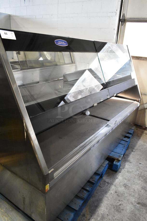 Metal commercial floor-style merchandiser with glass front, stainless steel construction, and internal shelving. Visible "Certified Hot Cooked Cabinet" label.