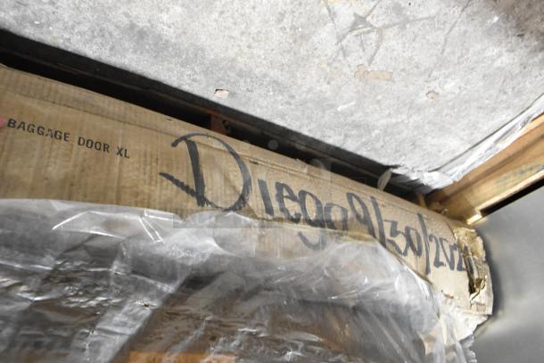 Cardboard box labeled "BAGGAGE DOOR XL" with handwritten markings, showing scratch and dent packaging. Contains LED emergency lights.
