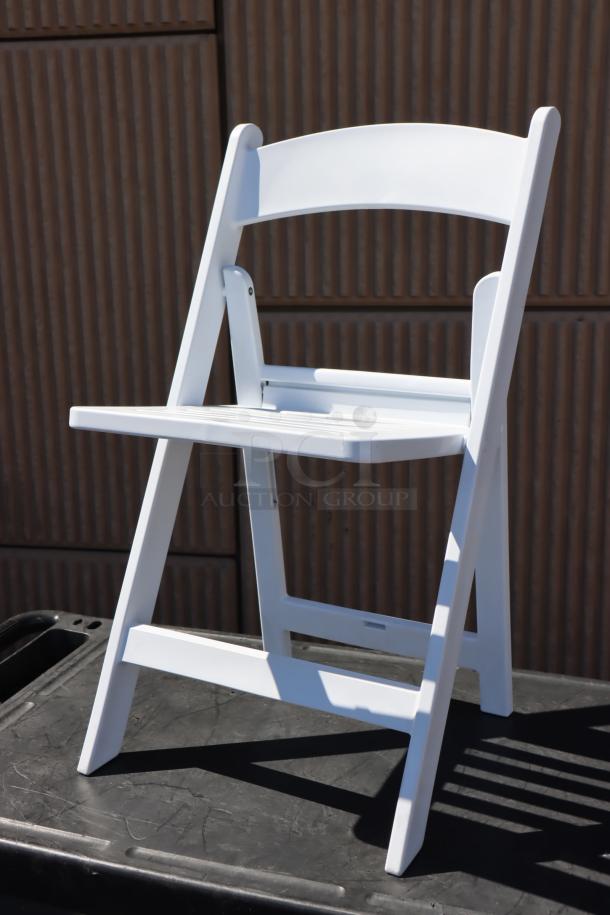 Lancaster Table & Seating white resin folding chair with slatted seat, model 427FCRSLTWHT. Packaging damaged, minor scratches possible. Lot of 28 chairs.