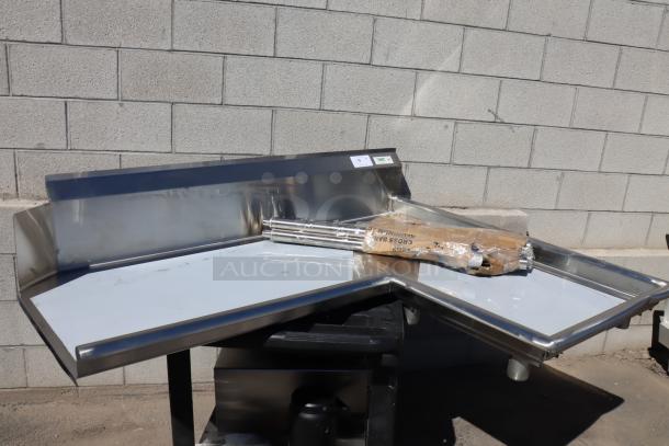 Brand new Regency 600CDTI48R 4' L-shape stainless steel dishtable with dent on right island edge. Includes legs.