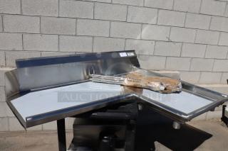 Brand new Regency 600CDTI48R 4' L-shape stainless steel dishtable with dent on right island edge. Includes legs.