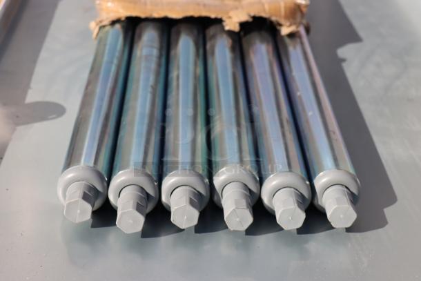 Close-up of six metal legs for the Advance Tabco TT-308X stainless steel work table, wrapped, showing minor wear.