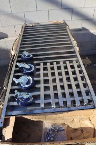Brand new Regency 600PR20316K 20 pan stainless steel bun rack, unassembled. Rain-damaged packaging visible.