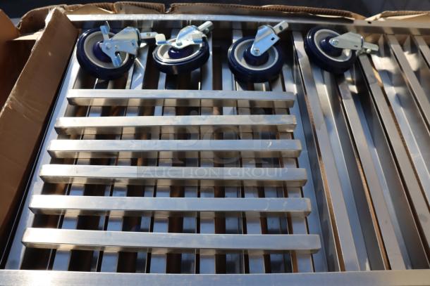 Brand new Regency 600PR20316K stainless steel 20 pan rack, unassembled, with wheels shown; packaging damaged by rain.
