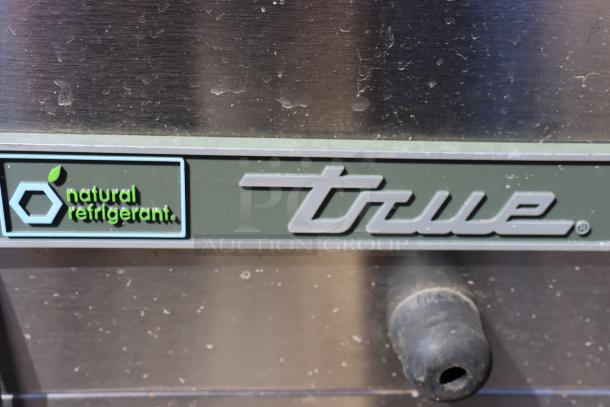 True TMC-58-S-DS-SS-HC milk cooler with natural refrigerant label, stainless steel, 58 1/4", minor scratches, dented bottom.