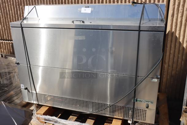 True TMC-58-S-DS-SS-HC milk cooler, stainless steel, 58 1/4", dented bottom, light scratches near handles. Model tag visible.