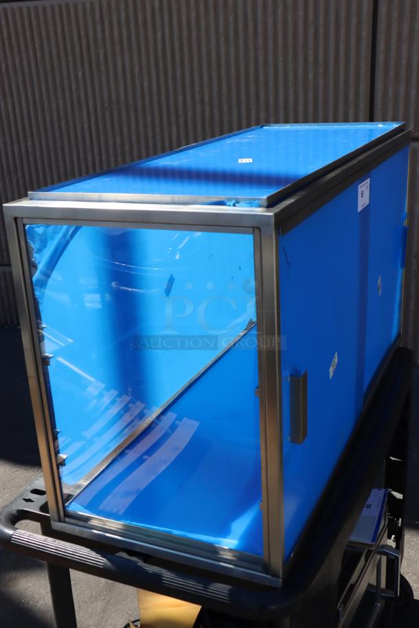 Brand new Cal-Mil 22323-55 3-tier bakery display case. Stainless steel frame, blue protective film. Missing base panel.