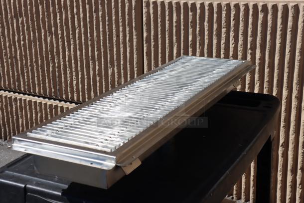 Brand new Regency 600FT1242SS 12"x42" stainless steel floor trough with grate; 2 bent fins on grate.