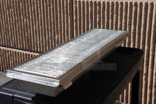 Brand new Regency 600FT1242SS 12"x42" stainless steel floor trough with grate; 2 bent fins on grate.
