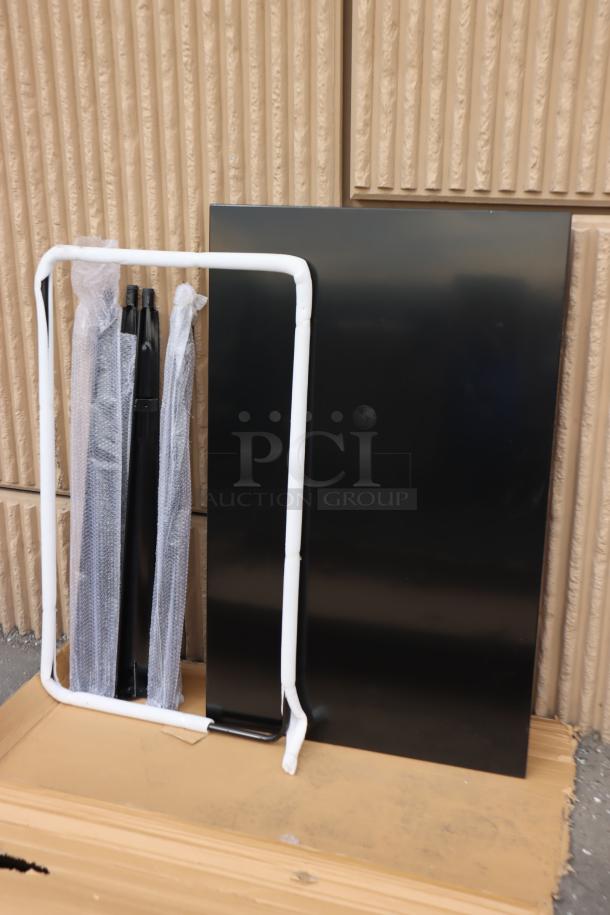 Brand new Lancaster Table & Seating Alloy 48" x 30" unassembled onyx black bar-height outdoor table with scratch-and-dent marks.