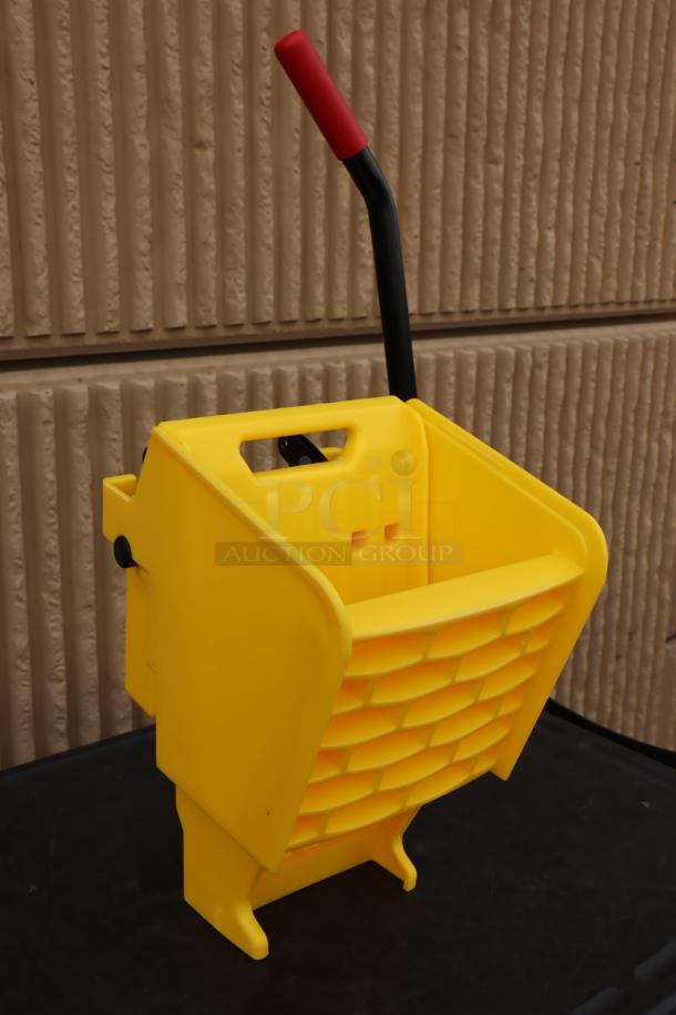 Brand new Rubbermaid® 2064959 WaveBrake® yellow mop wringer with red handle. Durable design, ideal for commercial use.