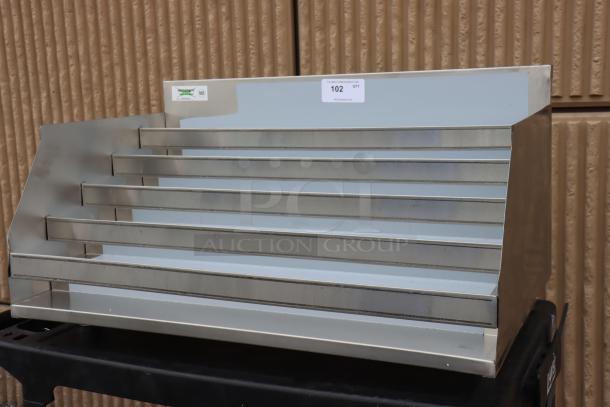 Brand new Regency 600LDR2336 liquor display rack, five-tiered, stainless steel, 36"x23", slight scratches visible.