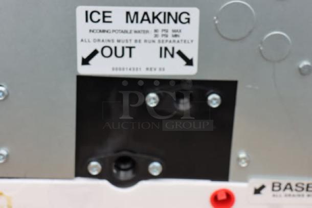 Alt text: "Label on Manitowoc IYT1200A-261 ice machine, indicating water intake and outflow for ice making."