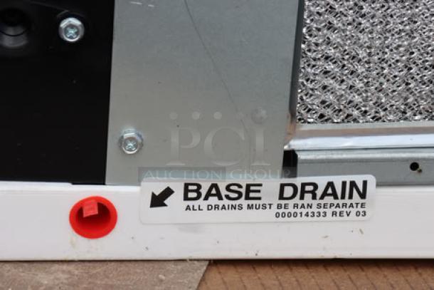 Manitowoc IYT1200A-261 Ice Machine; base drain label visible; out of packaging; cracked plastic top; minor dents present.