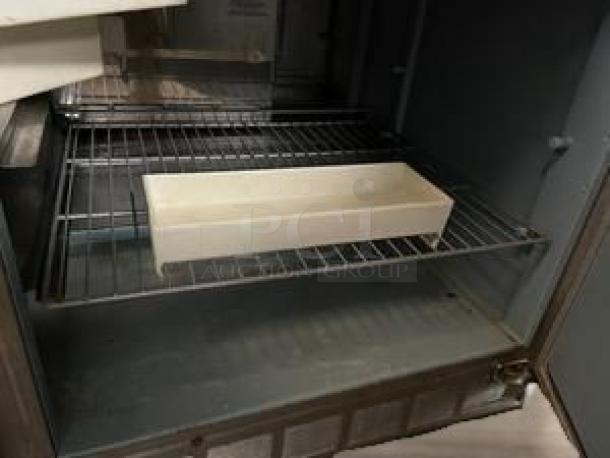 Delfield 2-door sandwich/salad prep table. Excellent condition, fully tested, 115V AC. Includes interior shelving.