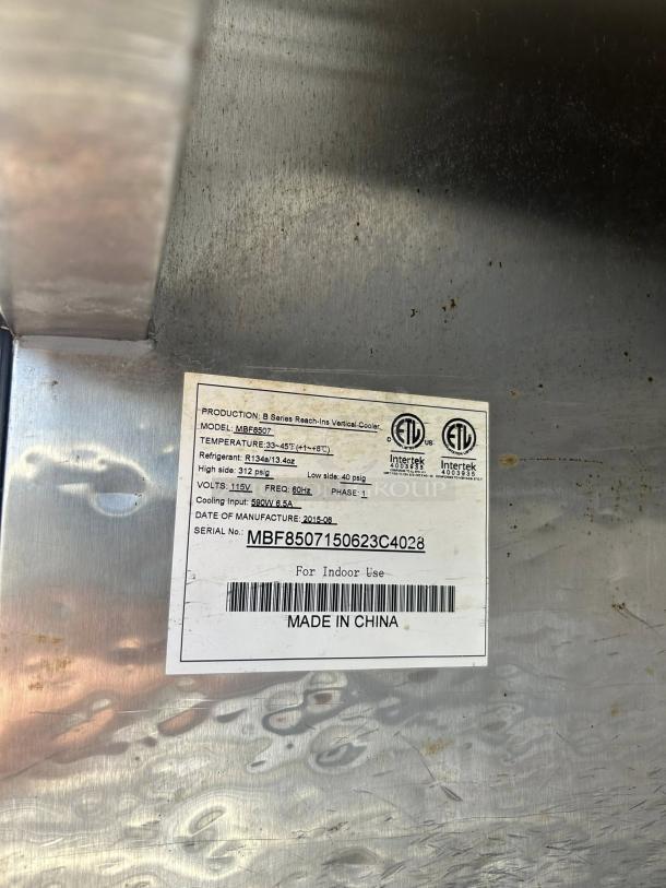 Label on Atosa MBF8507GR refrigerator shows model, refrigerant info, voltage, and manufacture date. Made in China.