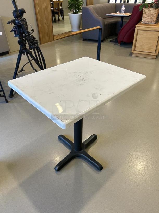 White 36"x30" dining table with sturdy black base. In great condition, minimal surface wear. Ideal for dining areas.