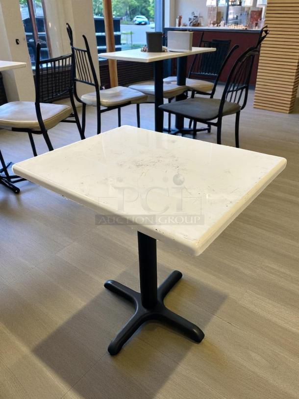 White dining table, 36" x 30", in great condition with a sturdy black base. Perfect for dining spaces.