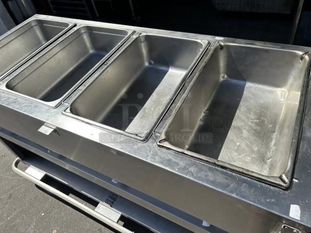 Duke E304 58 3/8" hot food table with 4 wells and cutting board, 240v/1ph, stainless steel, tested and working.