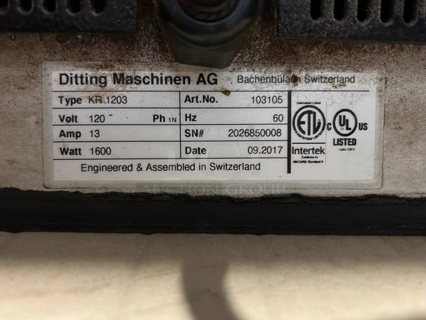 Ditting KR1203 coffee grinder label shows model, voltage 120V, amp 13, watt 1600, and manufacture date 09.2017, made in Switzerland.