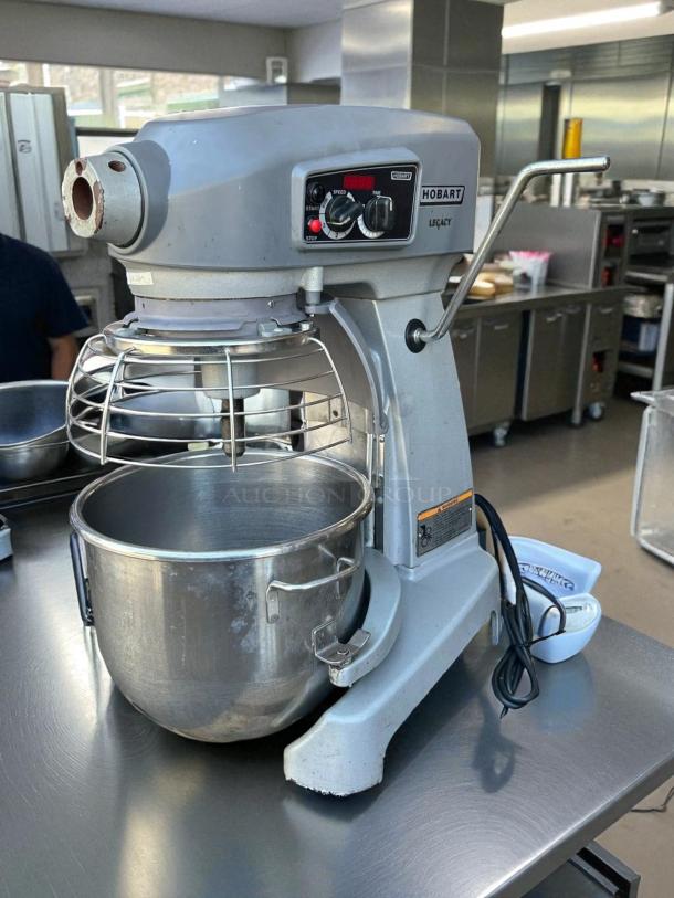 Hobart Legacy+ HL200 20 Qt. planetary mixer with guard, silver, on stainless counter, includes standard accessories, tested.