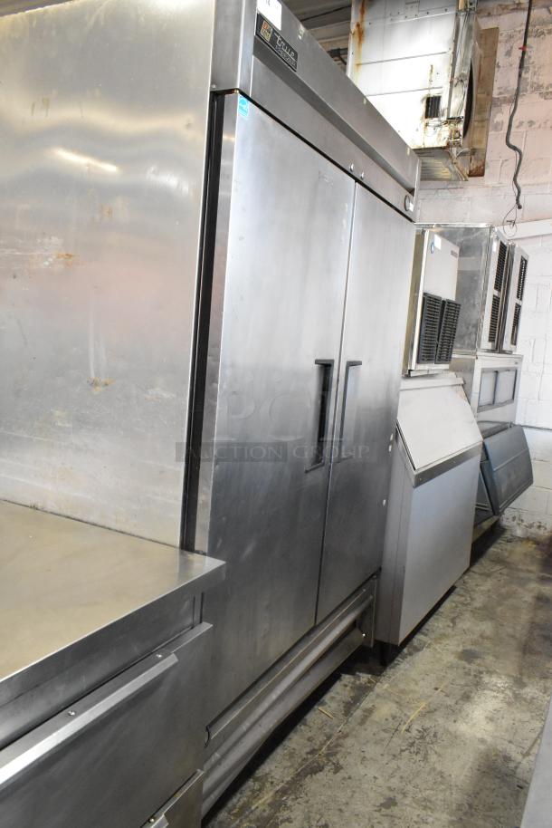 True T-49F stainless steel commercial 2-door reach-in freezer on casters, poly-coated rack, visible minor wear, model label shown.