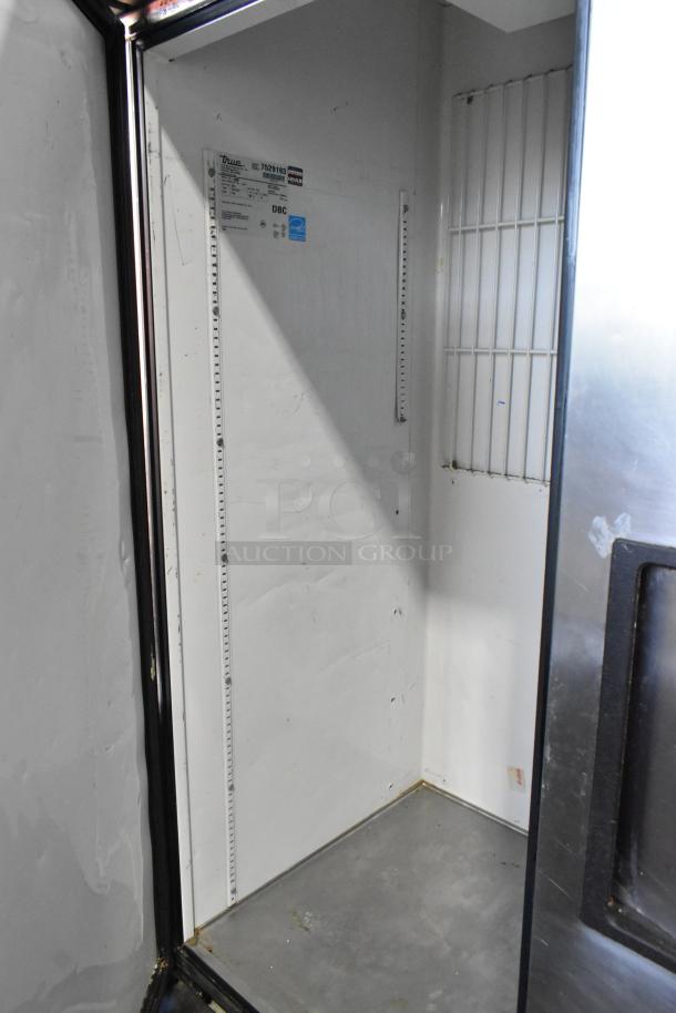 True T-49F commercial 2-door freezer interior view, showing stainless steel construction and poly-coated rack on commercial casters.