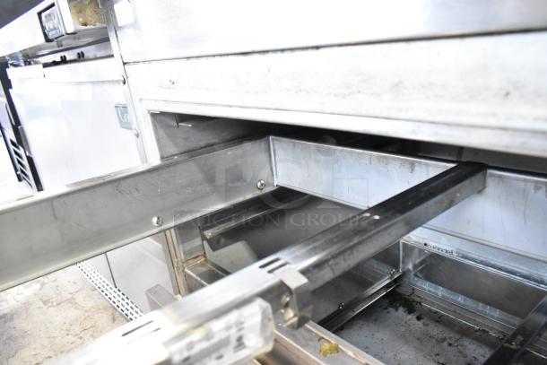 Stainless steel 2-drawer undercounter cooler, 115 volts, 1 phase, in good condition, interior view with shelves.