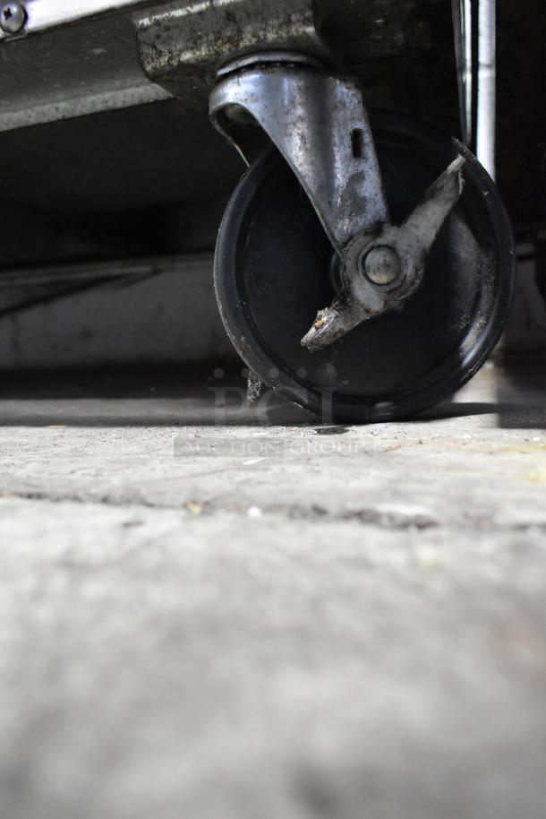 Close-up of a commercial caster wheel on a Beverage Air WTR60A stainless steel undercounter cooler, showing wear.