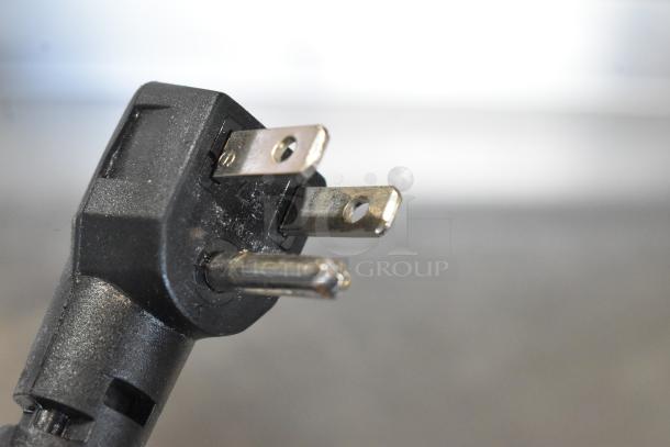 Close-up of a three-prong electrical plug for the Continental SW48-18M prep table, showing prongs in good condition.