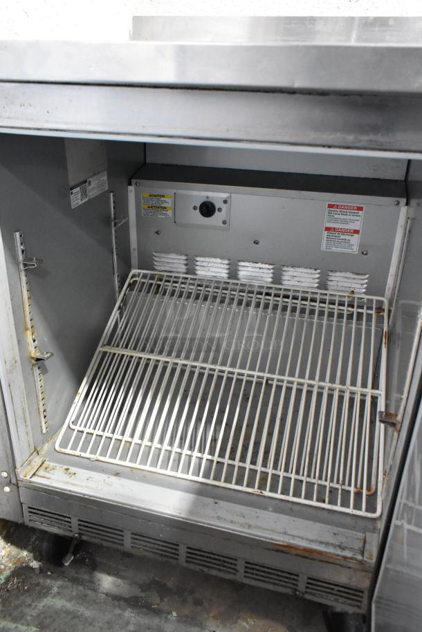 Beverage Air stainless steel single-door work top cooler on casters, showing interior rack and visible wear. 115 volts, 1 phase.