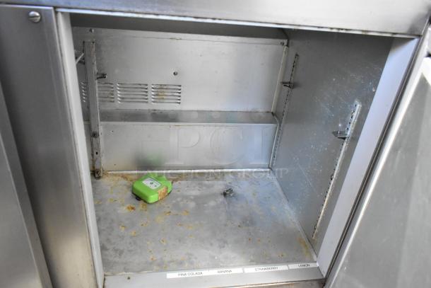 Beverage Air UCR48A stainless steel two-door undercounter cooler, visible internal shelving, commercial casters, some wear.