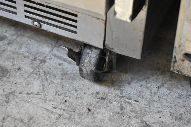 Beverage Air UCR48A stainless steel undercounter cooler on casters, showing caster detail, used condition.