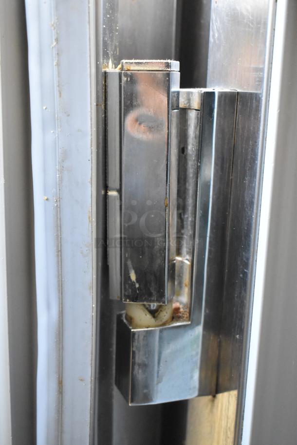 Stainless steel hinge detail, Beverage Air UCR48A cooler. Signs of minor wear and rust visible on metal surface.