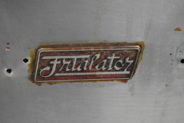 Pitco Frialator 40S logo on stainless steel surface, showing wear and rust.