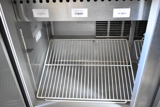 Beverage Air SPE48-18M Stainless Steel Sandwich Salad Prep Table with wire shelving, barcodes visible, on commercial casters.